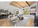 Expansive living room with a stone fireplace, wood-beamed ceiling, and open layout to the kitchen at 318 Montrose Dr, Waxhaw, NC 28173