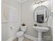 Chic powder room with a pedestal sink, elegant mirror, and decorative accents for a touch of sophistication at 318 Montrose Dr, Waxhaw, NC 28173