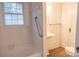 Bright bathroom with white tiles, window, grab bar, and wood-look flooring at 35 E Catawba St, Belmont, NC 28012