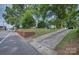 Charming white two-story home with mature trees, a brick wall, and a long driveway at 35 E Catawba St, Belmont, NC 28012