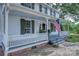 Charming front porch with American flag, white railings, and a view of the landscaped yard at 35 E Catawba St, Belmont, NC 28012
