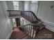 Elegant staircase with carpeted steps, dark wood railings, and natural light from nearby windows at 35 E Catawba St, Belmont, NC 28012