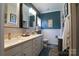 Bright bathroom featuring double vanity, wainscoting, blue accent wall, and toilet at 403 Garner Dr, Salisbury, NC 28146