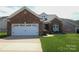 Charming single-story brick home featuring an attached two-car garage and well-maintained lawn at 403 Garner Dr, Salisbury, NC 28146