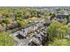 An aerial view showcases residential townhomes with lush trees, grassy areas, and urban buildings visible in the background at 4038 City Homes Pl, Charlotte, NC 28209