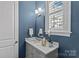 Well-lit bathroom features custom vanity, blue accent wall and window with plantation shutters at 4038 City Homes Pl, Charlotte, NC 28209