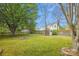 Wide backyard featuring a storage shed, lush lawn, and a stone fire pit nestled in a peaceful setting at 4608 Mabry Pkwy, Rock Hill, SC 29732