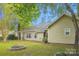 A home's backyard features a fire pit, green lawn, and mature trees with privacy hedges in view at 4608 Mabry Pkwy, Rock Hill, SC 29732