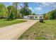 Well-maintained home with a wide driveway, green lawn, and lush trees surrounding the property at 4767 Stratford Ln, Denver, NC 28037