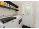 Laundry room with full size washer and dryer, shelving, and an exterior door at 4767 Stratford Ln, Denver, NC 28037