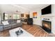 Spacious living room featuring a fireplace, hardwood floors, and open access to the kitchen at 4767 Stratford Ln, Denver, NC 28037
