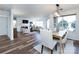 Spacious living room with fireplace, wood floors, and dining area with bright windows at 5007 Sharon Rd # S, Charlotte, NC 28210