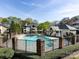 Community pool surrounded by a fence, greenery, and nearby buildings at 5007 Sharon Rd # S, Charlotte, NC 28210
