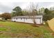 Exterior showcasing a newly painted white home with dark metal roofing in a mature setting at 6057 Highway 97 Hwy, Hickory Grove, SC 29717