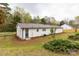 Exterior showcasing a newly painted white home with dark metal roofing in a mature setting at 6057 Highway 97 Hwy, Hickory Grove, SC 29717