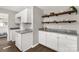 Kitchen area with white cabinets, granite countertops, wooden floating shelves, and hardwood floors at 6057 Highway 97 Hwy, Hickory Grove, SC 29717