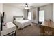 Bright bedroom featuring a ceiling fan, natural light, and surf board decor at 6114 Abergele Ln, Matthews, NC 28104