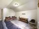 Bonus room with carpet floors, comfortable sofas, white brick accent wall, and TV mount at 6114 Abergele Ln, Matthews, NC 28104