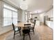Bright dining area features a round table, wood floors, natural light, and an open view into the white kitchen at 6114 Abergele Ln, Matthews, NC 28104