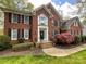 Beautiful brick home with a manicured lawn, lush landscaping and black window shutters create curb appeal at 6114 Abergele Ln, Matthews, NC 28104