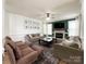 Spacious living room boasts a fireplace, ceiling fan, tv and neutral-toned furnishings with hardwood floors at 6114 Abergele Ln, Matthews, NC 28104