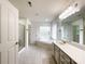 Bright bathroom with double sinks, tiled floors, glass shower, and a jacuzzi tub by a window at 6114 Abergele Ln, Matthews, NC 28104