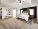 Spacious main bedroom with a tray ceiling, carpet floors, and a seating bench beneath a wall of portraits at 6114 Abergele Ln, Matthews, NC 28104
