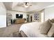 Bright main bedroom featuring carpet floors, walk-in closet, and a television above a cabinet at 6114 Abergele Ln, Matthews, NC 28104