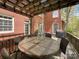 Inviting patio space with a large round table, wicker chairs, and overhead pergola at 6114 Abergele Ln, Matthews, NC 28104