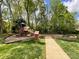 Community playground with swings, slides, and a bench for to enjoy at 6114 Abergele Ln, Matthews, NC 28104