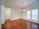 Bright dining room with hardwood floors, elegant chandelier, large windows, and beautiful trim at 7524 Common Oak Dr, Stanley, NC 28164
