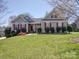 Well-maintained home featuring a manicured lawn, red shutters, and gray siding at 7524 Common Oak Dr, Stanley, NC 28164