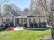 Charming home featuring a well-manicured lawn and red shutters enhancing its curb appeal on a sunny day at 7524 Common Oak Dr, Stanley, NC 28164