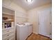 Laundry room area featuring washer and dryer, storage cabinet and access to outside at 7524 Common Oak Dr, Stanley, NC 28164