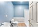 Bathroom featuring a white shower stall, toilet, sink and wood-look flooring at 8619 Delamere Ln, Charlotte, NC 28269