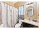 Well-lit bathroom featuring a vanity with decorative mirror and a shower with a floral curtain at 8619 Delamere Ln, Charlotte, NC 28269