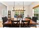 Dining room featuring modern light fixture over a dark wood table and chairs at 8619 Delamere Ln, Charlotte, NC 28269