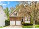 Charming two-story home featuring a brick facade, a two-car garage, and mature trees at 8619 Delamere Ln, Charlotte, NC 28269