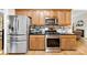 Kitchen featuring stainless steel appliances, granite countertops, and warm oak cabinets at 8619 Delamere Ln, Charlotte, NC 28269