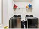 Bright laundry room with washer, dryer, and shelving for storage and supplies at 8619 Delamere Ln, Charlotte, NC 28269
