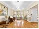Bright living room with hardwood floors, modern light fixture, and a bay window with decorative curtains at 8619 Delamere Ln, Charlotte, NC 28269