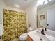 Well-lit bathroom featuring a vanity, framed mirror, neutral walls, and shower/tub with patterned curtain at 920 Ashworth Dr, Gastonia, NC 28054