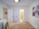 Neutral carpeted bedroom with a ceiling fan, closet, and ensuite bathroom with patterned shower curtain at 920 Ashworth Dr, Gastonia, NC 28054