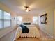 Well-lit bedroom featuring a ceiling fan, decorative headboard, and carpeted floor at 920 Ashworth Dr, Gastonia, NC 28054