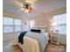 Well-lit bedroom featuring a ceiling fan, decorative headboard, and bedside table with lamps at 920 Ashworth Dr, Gastonia, NC 28054