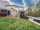 Exterior view of townhome featuring lawn, landscaping, and screened porch, with nearby parking at 920 Ashworth Dr, Gastonia, NC 28054