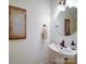 Bathroom featuring pedestal sink, round mirror, and elegant decor at 920 Ashworth Dr, Gastonia, NC 28054