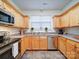 Well-lit kitchen with wooden cabinets, stainless steel appliances, and tile floors at 920 Ashworth Dr, Gastonia, NC 28054