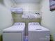 Laundry room featuring white washer and dryer, with wire shelving for storage and decor at 920 Ashworth Dr, Gastonia, NC 28054
