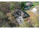An aerial view shows a charming home with a long drive, landscaping, and a detached building in a partially wooded lot at 103 Devonshire Ln, Salisbury, NC 28146